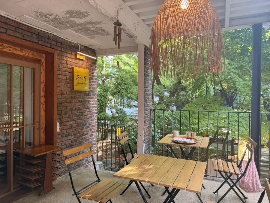 나무에 둘러싸인 카페 1층 창가 풍경