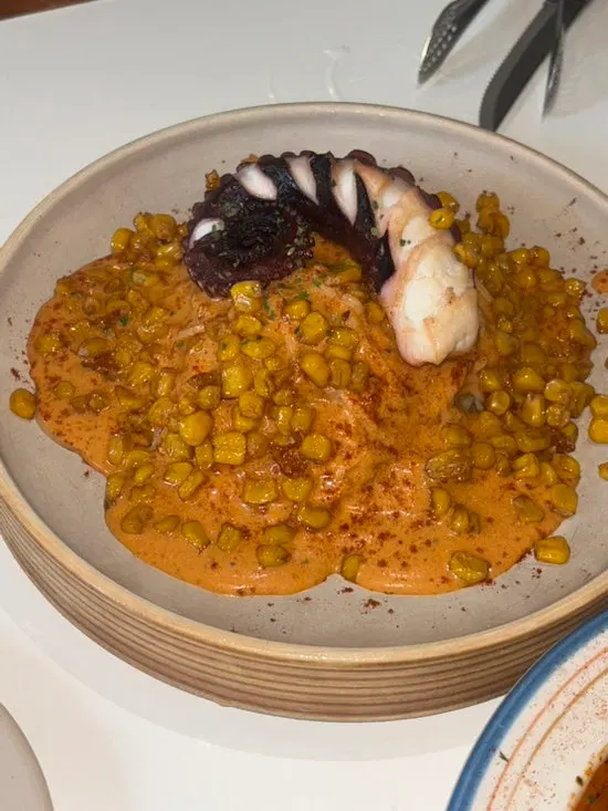 Ppolppo with octopus and corn over romesco sauce