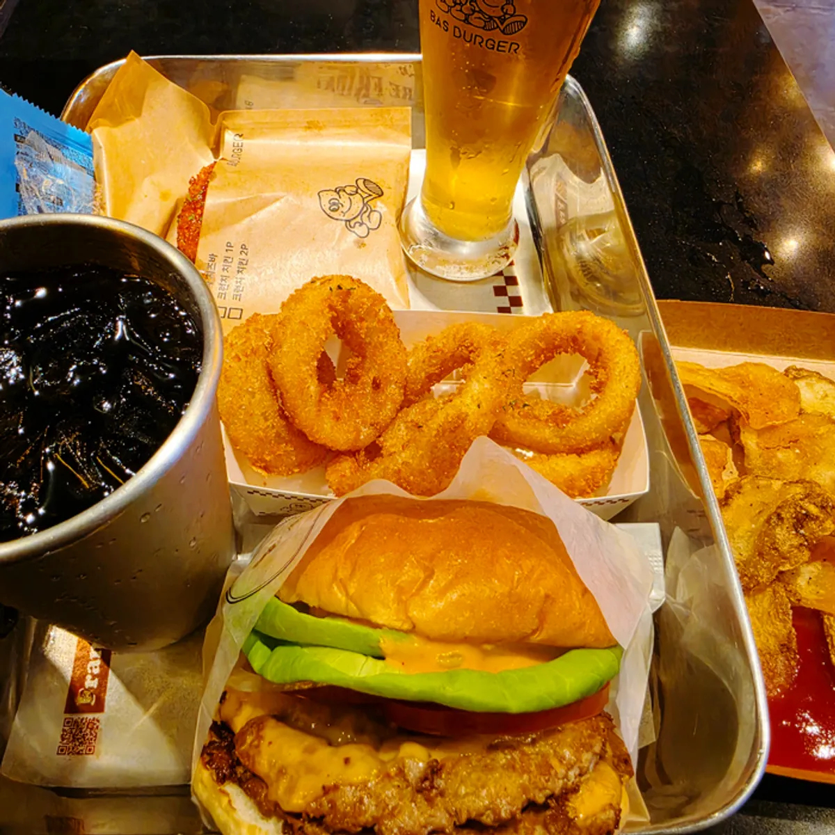 Double Bas Burger set with onion rings, chili mozza cheese bar, and Bas Lager