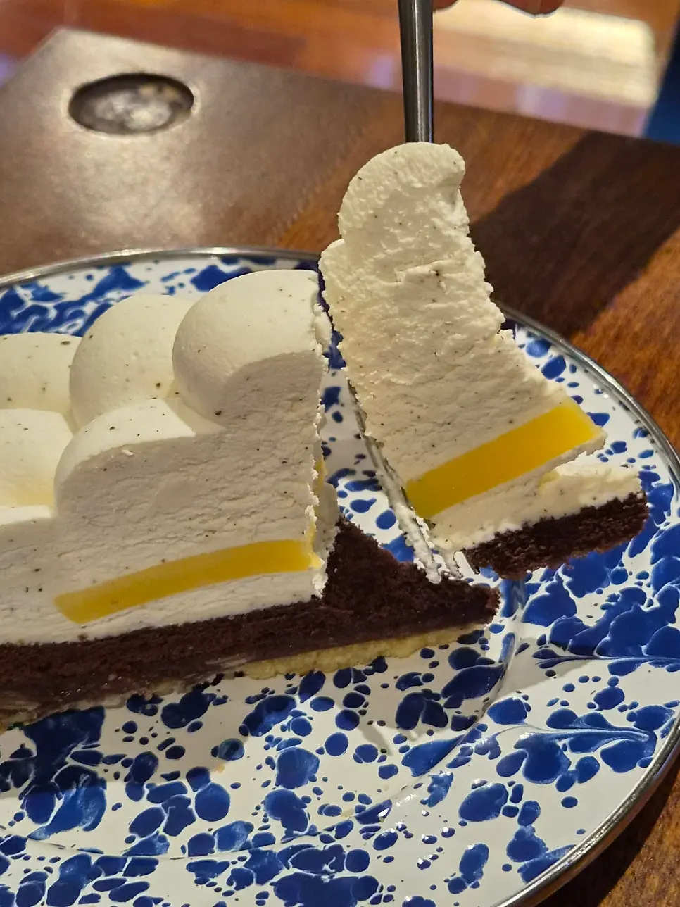 Tart cross-section with lemon coulis and chocolate sponge