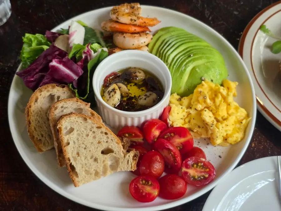 Plate with avocado, scrambled eggs, and grilled shrimp
