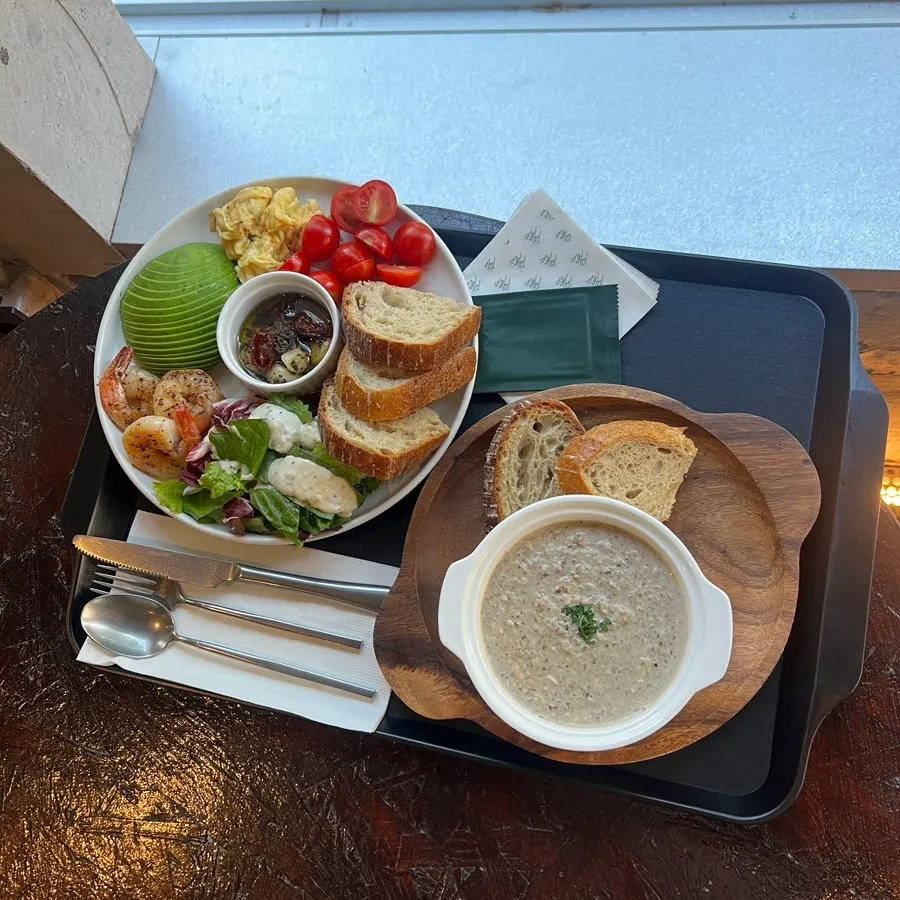 Table setting with soup of the day and grilled shrimp herb oil plate