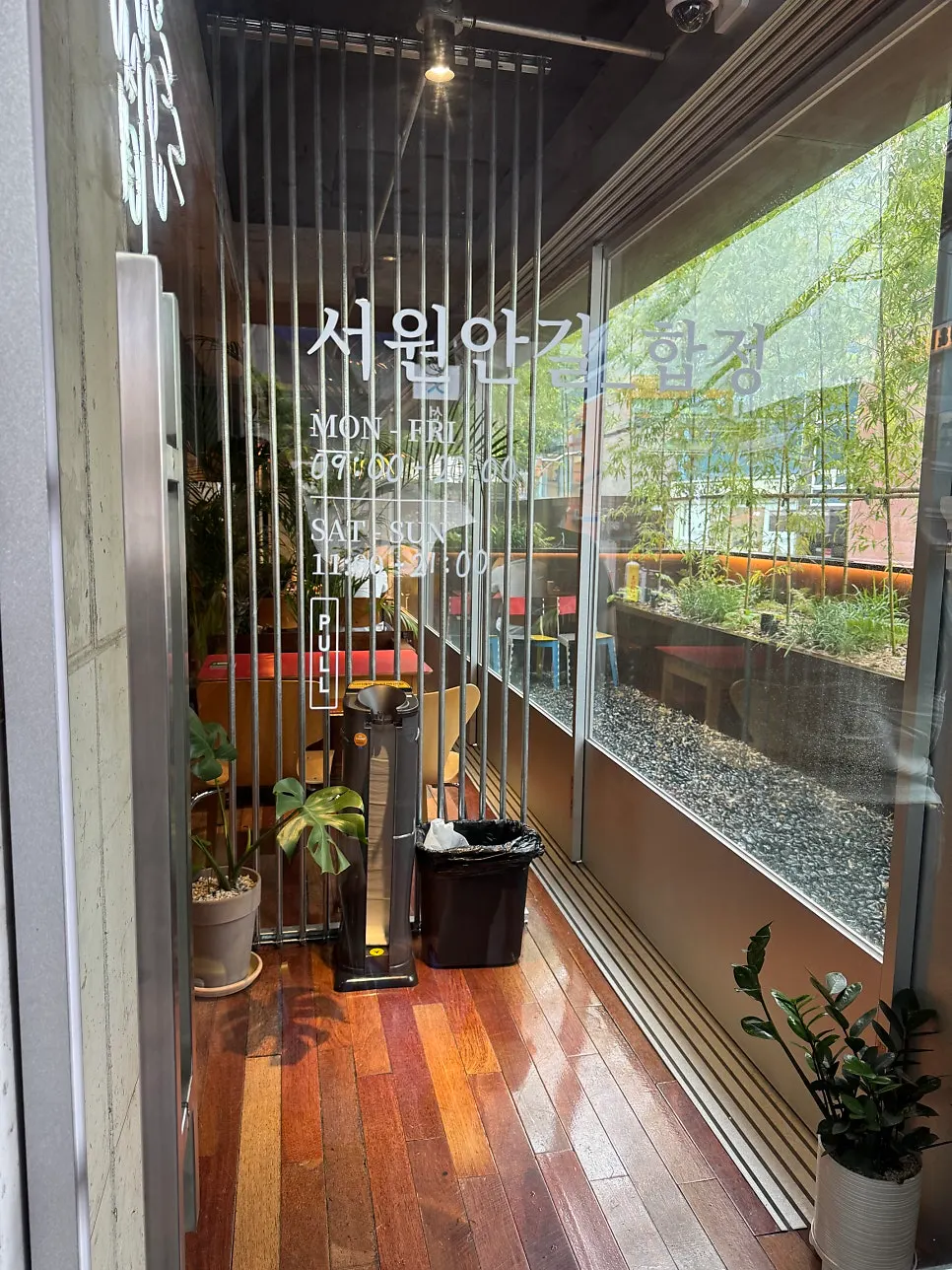 우드 인테리어와 화분이 있는 카페 내부