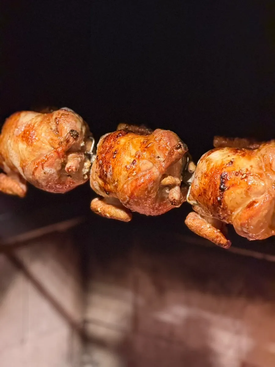 Close-up of chicken cooking in the charcoal roasting machine