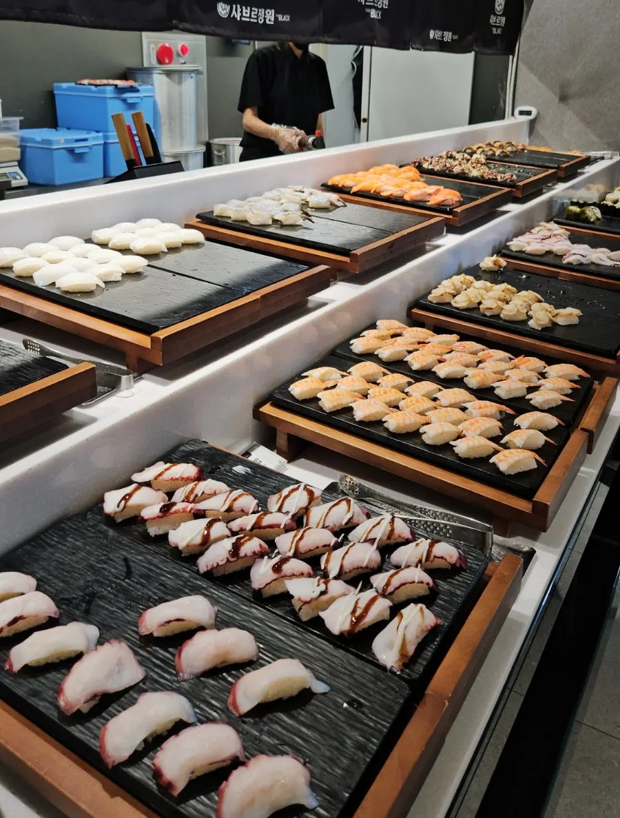 Plate of buffet sushi topped with generous slices of raw fish