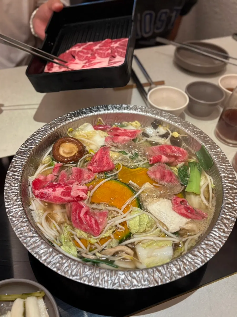 Swirling meat gently through the broth to cook