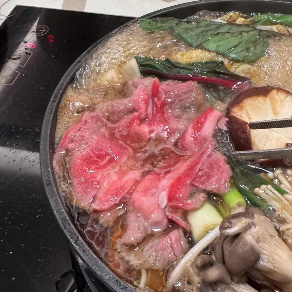 Vegetables added to the boiling sukiyaki broth in the pan