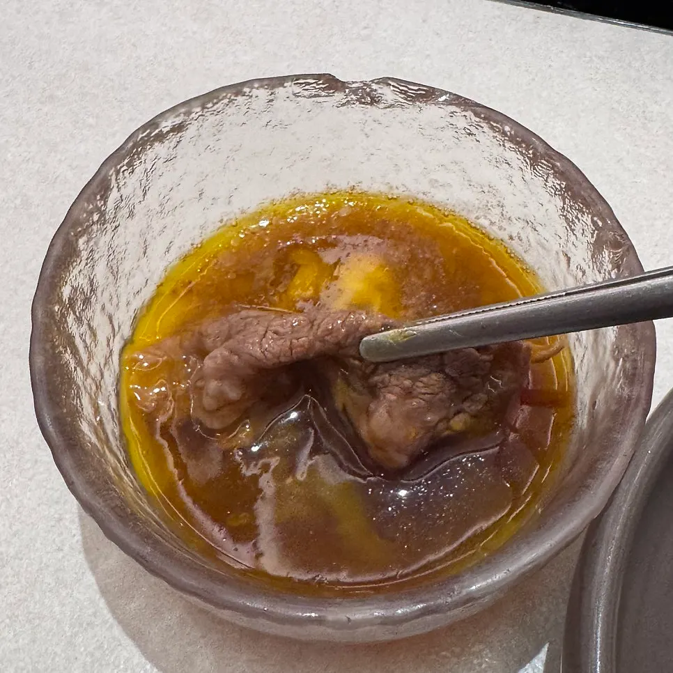 A slice of chuck flat being cooked in the broth