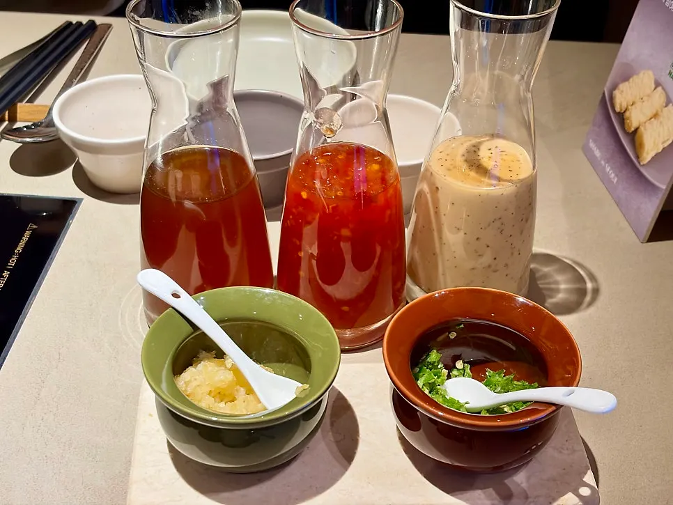 Yuzu ponzu sauce, chili sauce, and sesame sauce set on the table