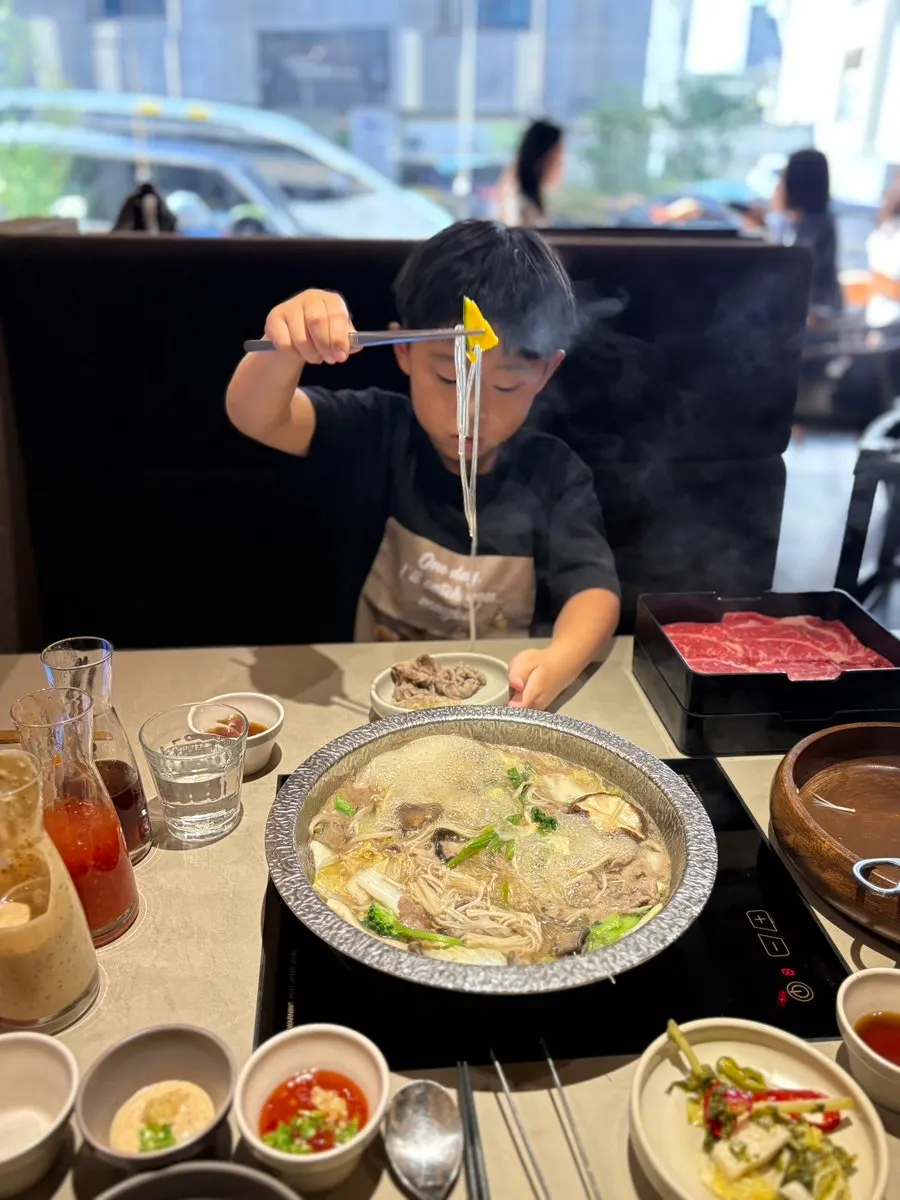 Cooking meat in the broth with tongs