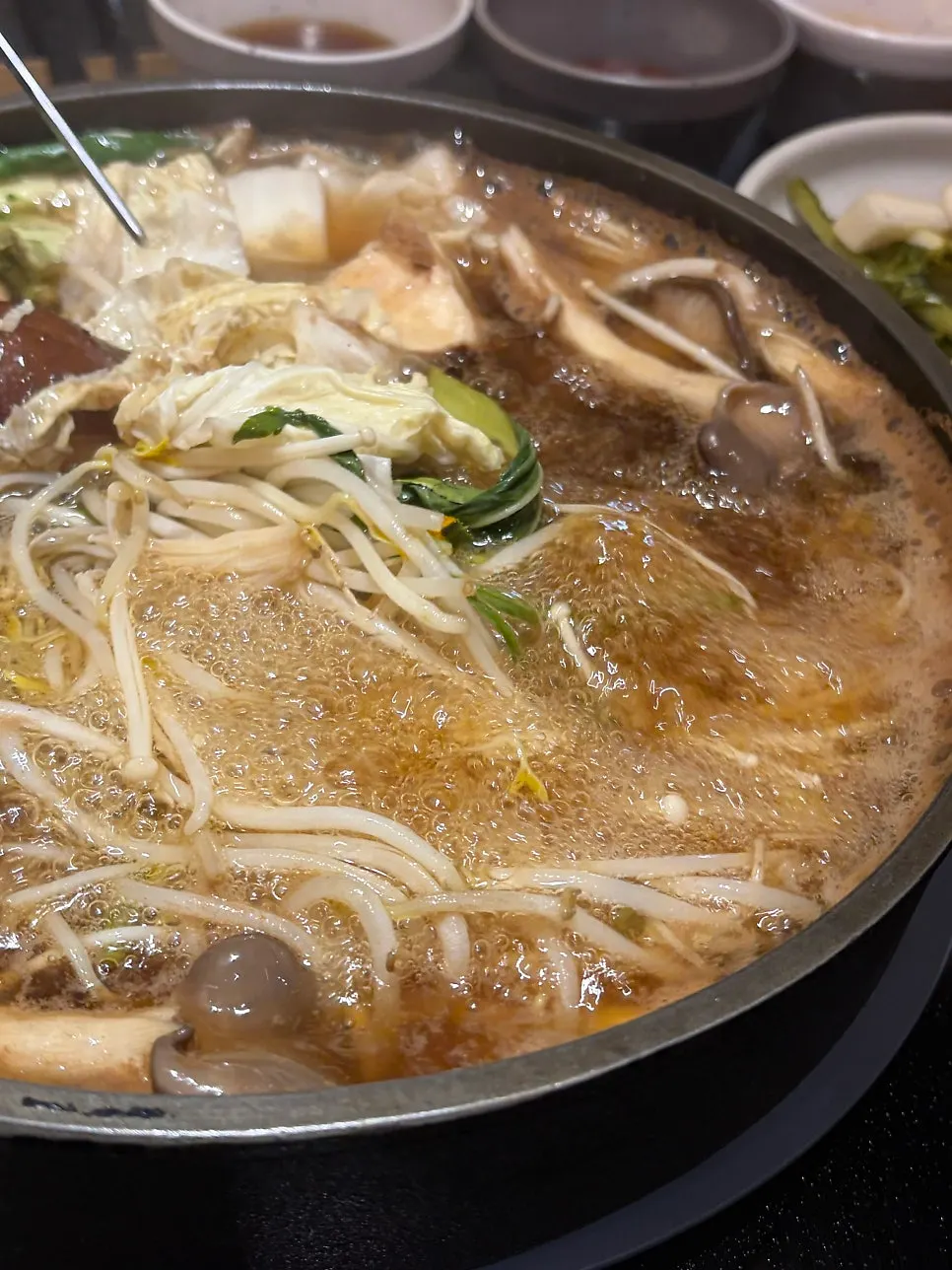 Sepotong daging sukiyaki dicelup ke telur mentah