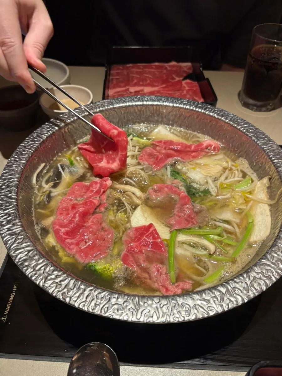 Pot of shabu-shabu with vegetables added first