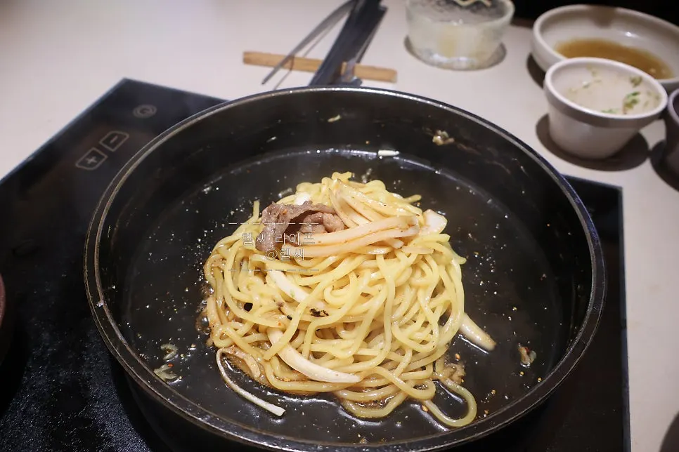 Pan with the broth poured out, starting to stir-fry the noodles
