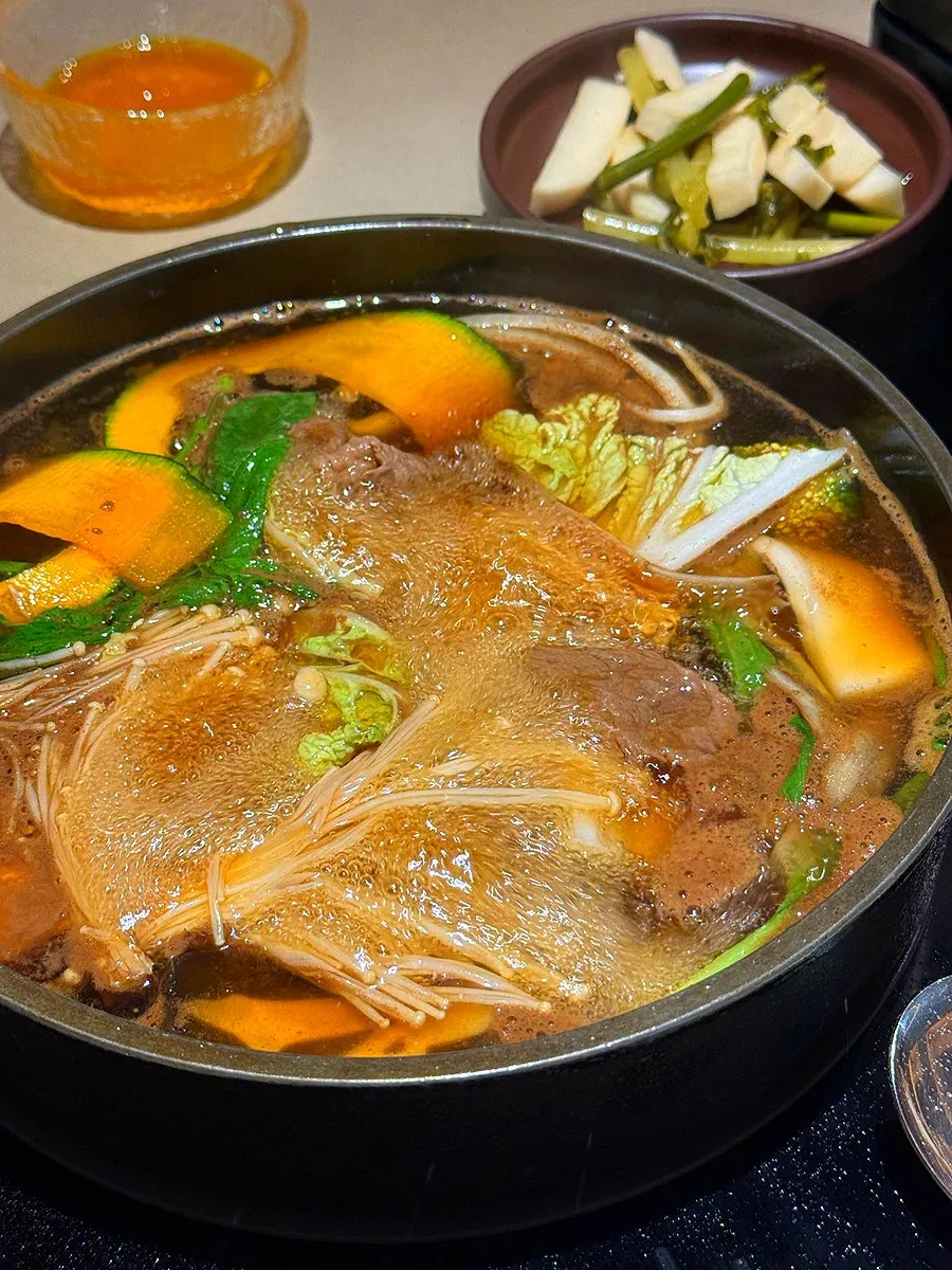 Vegetables and meat added into the boiling sukiyaki