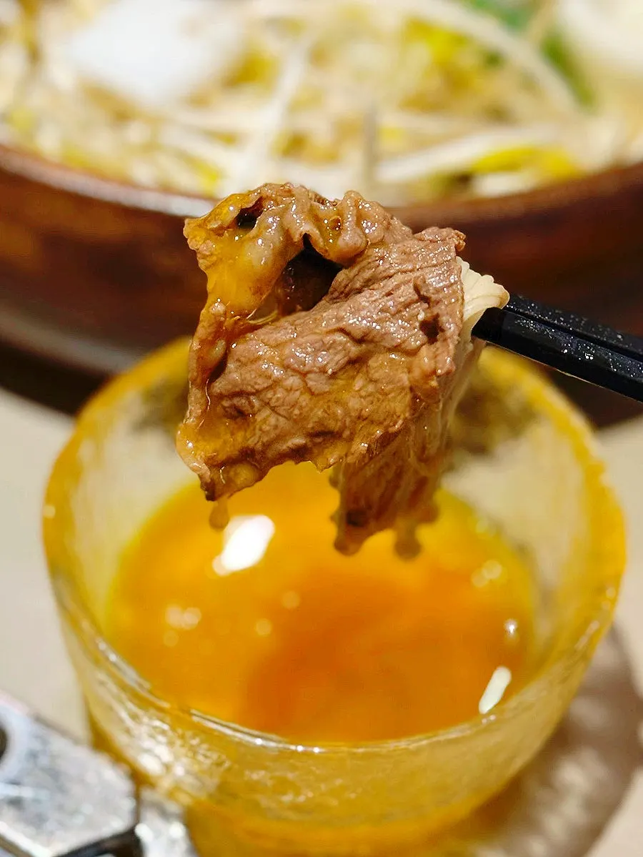 Dipping cooked chuck flap into egg yolk