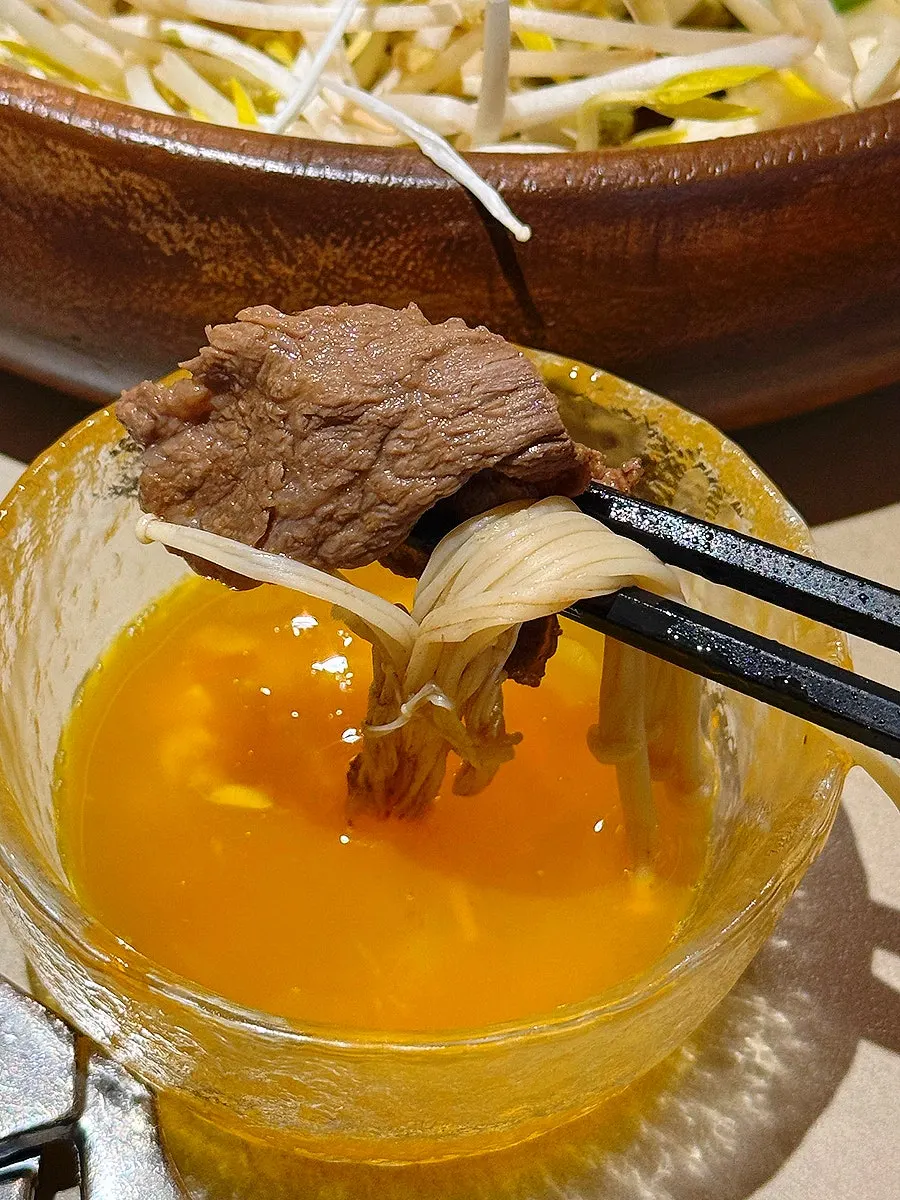 Piece of sukiyaki meat coated in egg yolk