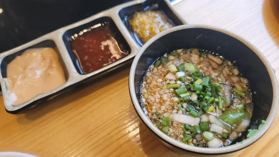 Vegetables and meat added into the boiling shabu-shabu pot