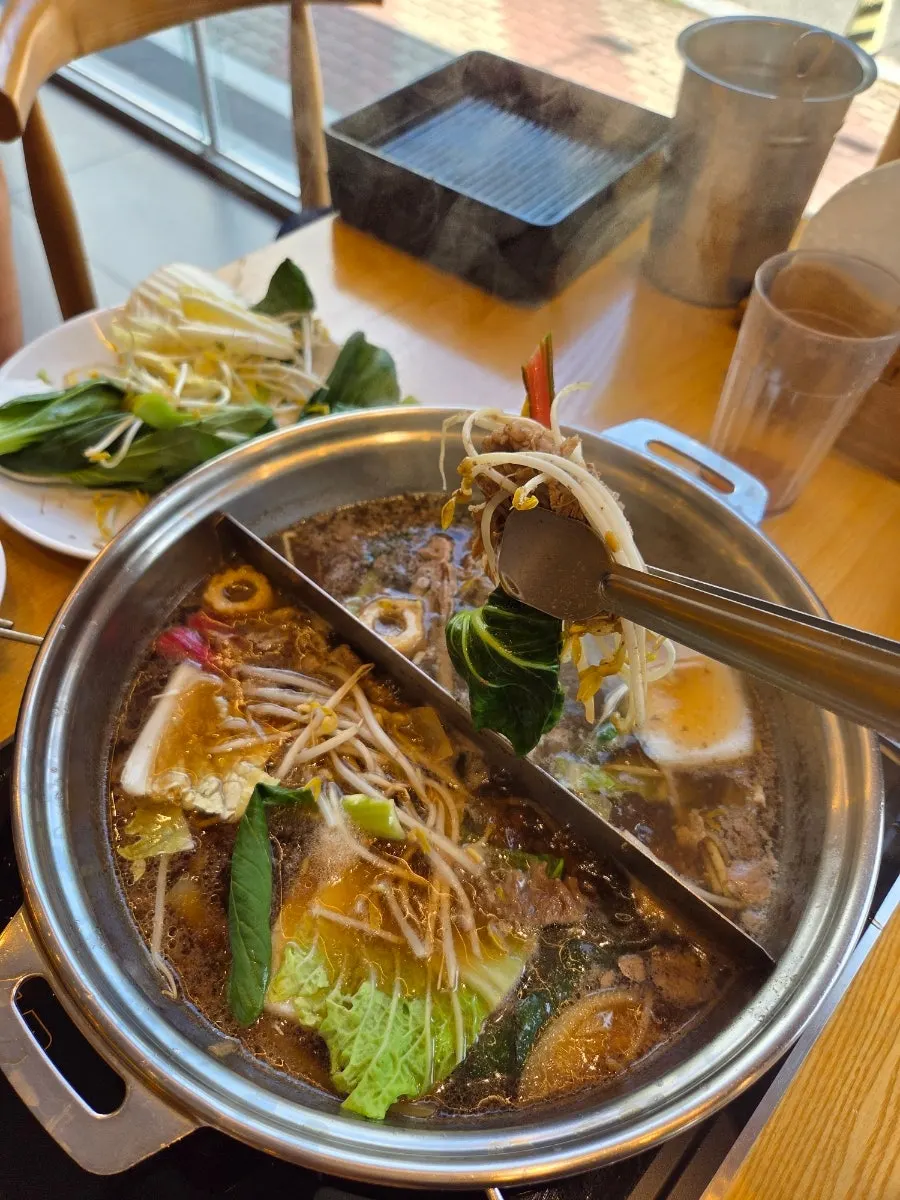 A shabu-shabu pot simmering with vegetables and beef