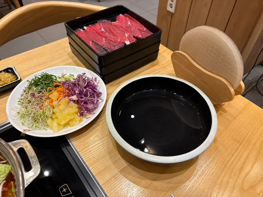 A plate of rice paper wraps and shabu-shabu ingredients