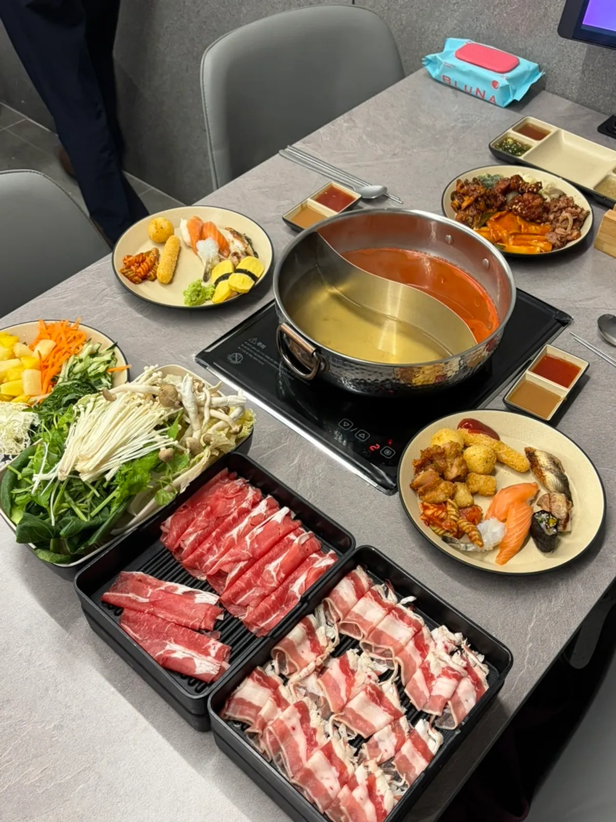 Table with shabu-shabu pot and buffet food