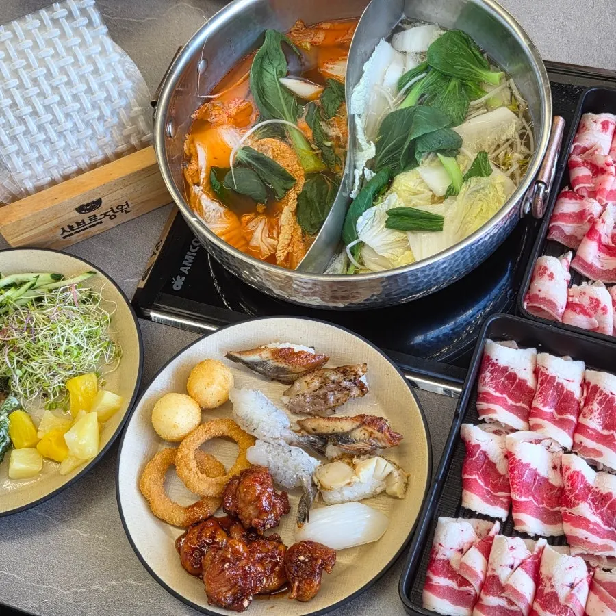 A full spread of vegetables and meat for shabu-shabu