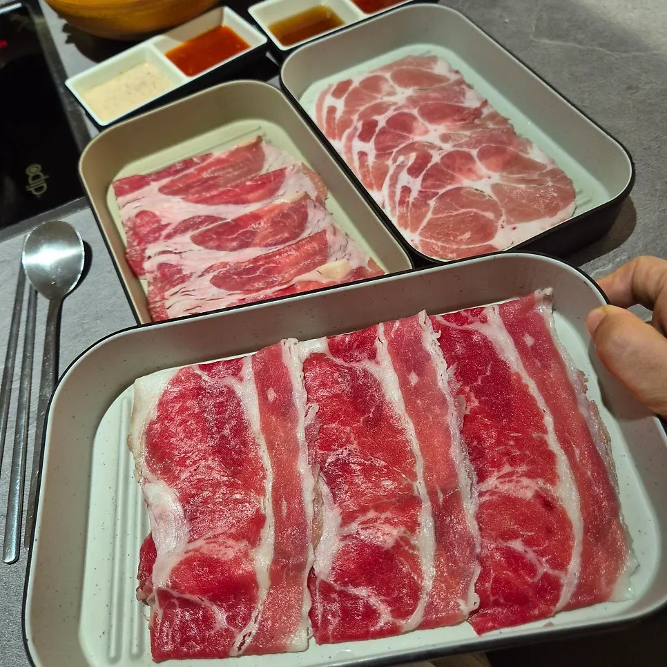 Thin-sliced beef and vegetables cooking in shabu-shabu broth