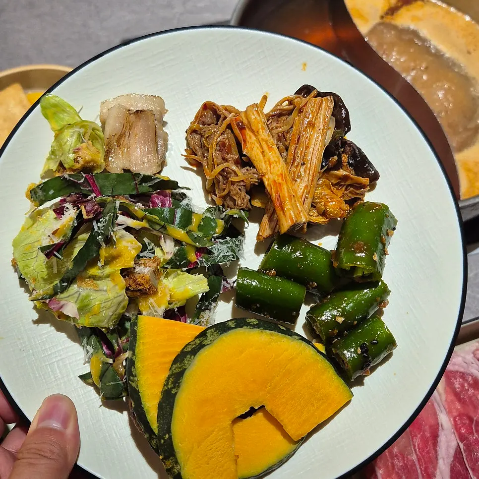 A plate of beef and vegetables cooked in broth