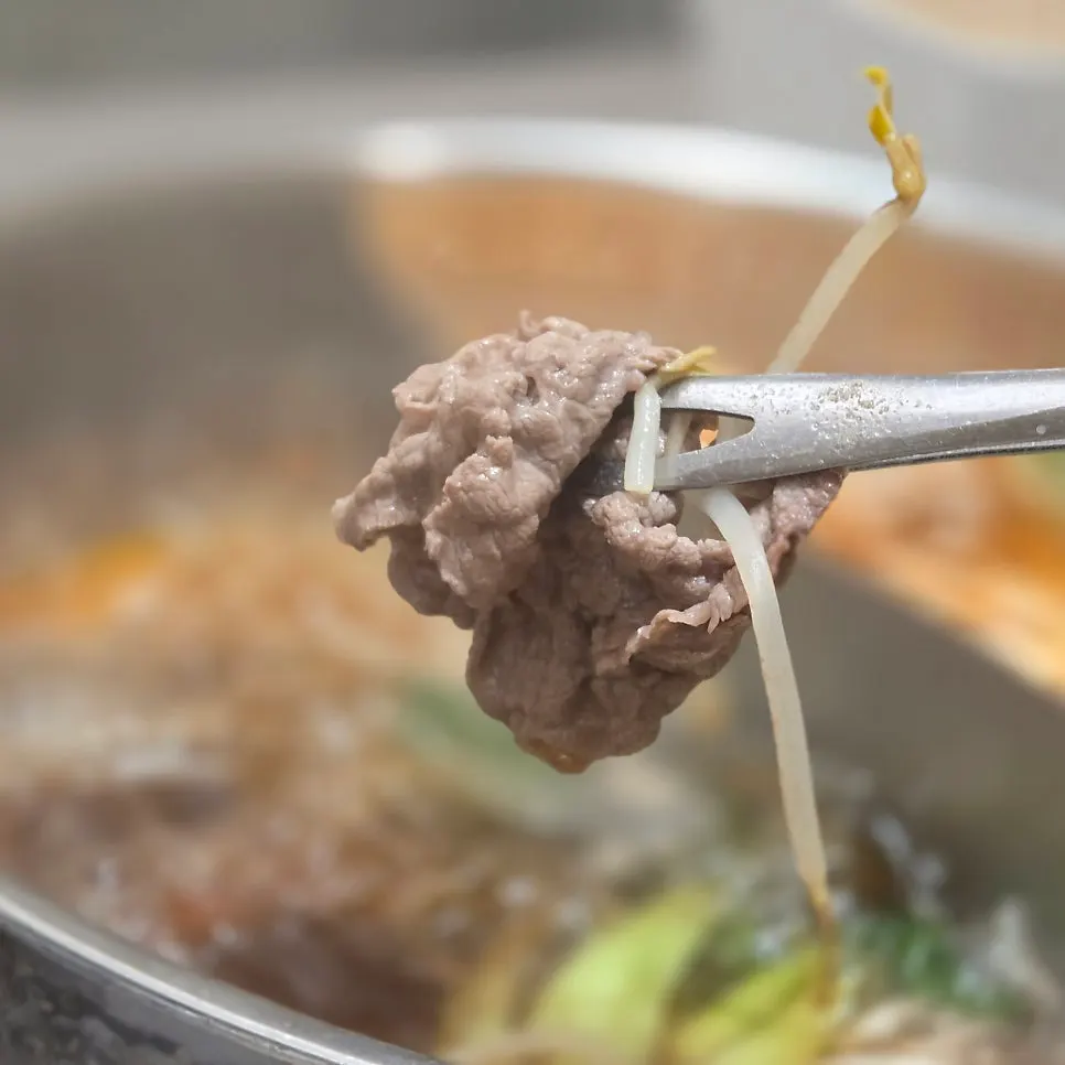 Shabu beef lifted out of the broth after blanching