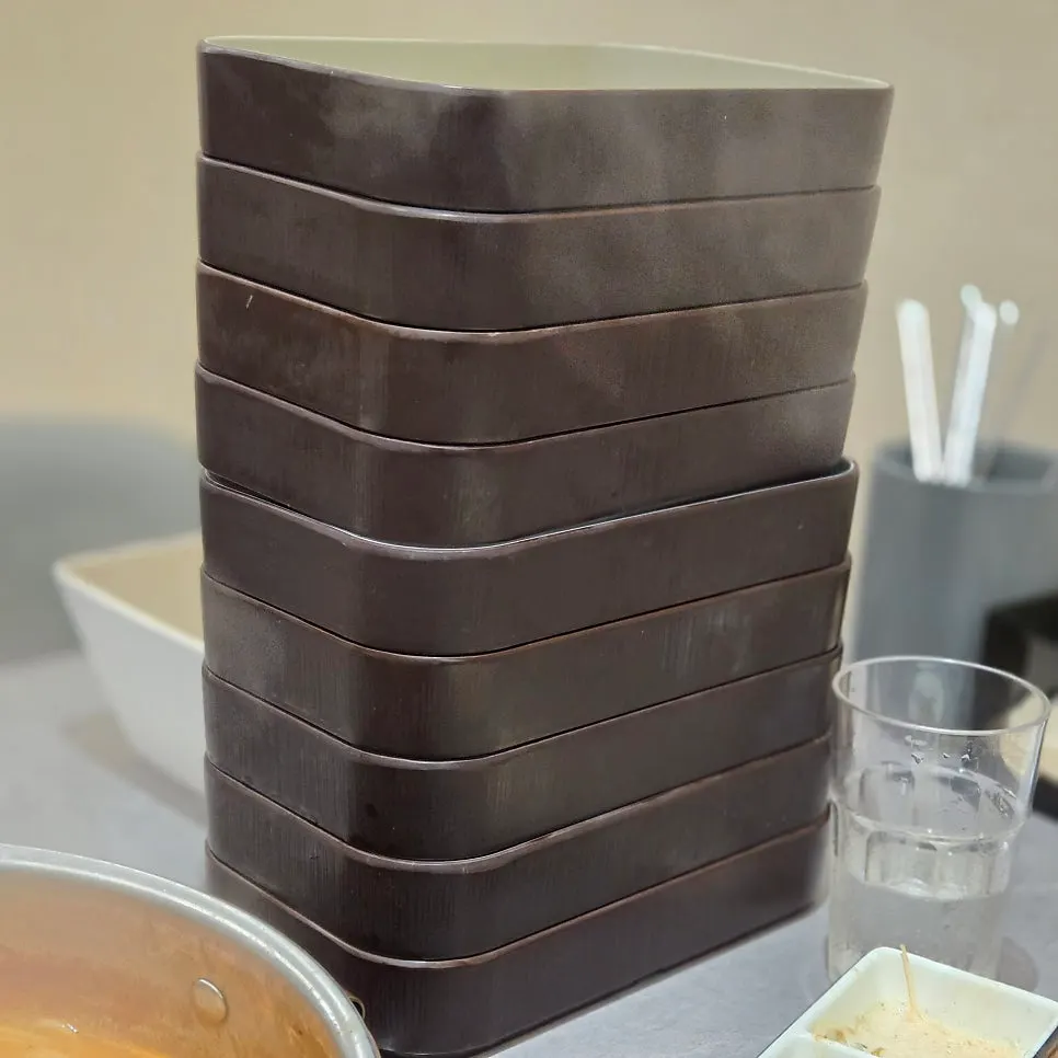 Tall stack of square meat trays