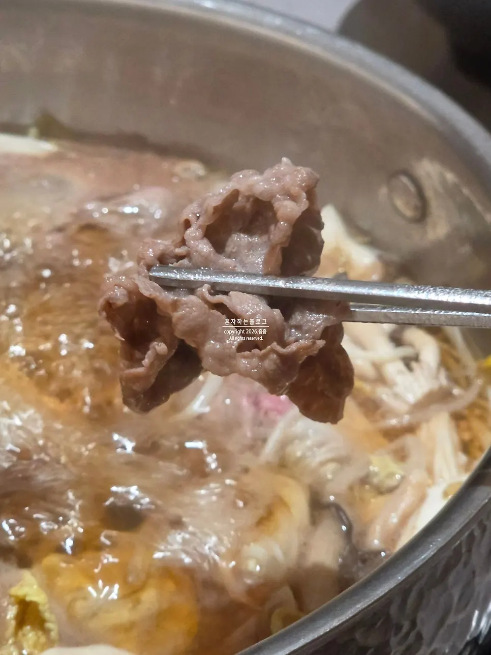 끓는 육수에 고기를 담가 익히는 모습