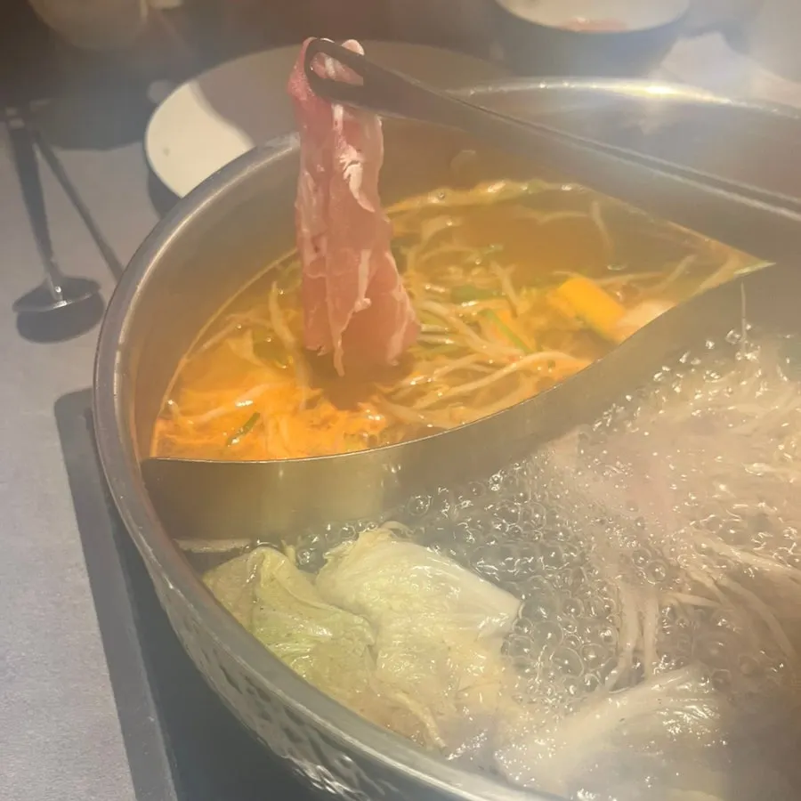 Shabu-shabu broth simmering half plain, half spicy