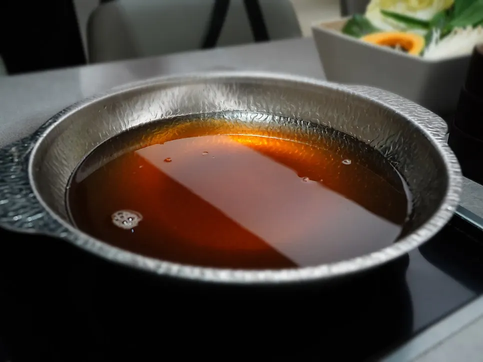 Pot of golden shiitake broth starting to boil