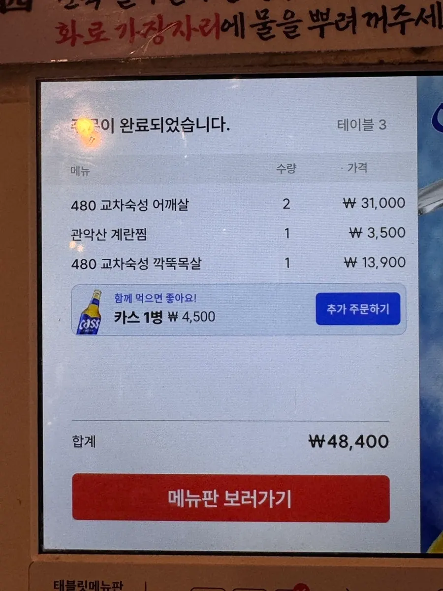 A child's hand choosing items on the tablet menu