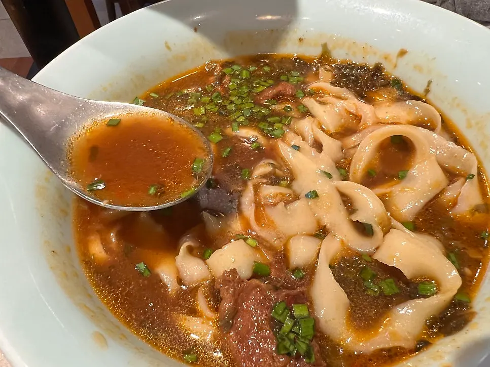 A full meal spread with the spicy knife-cut noodles