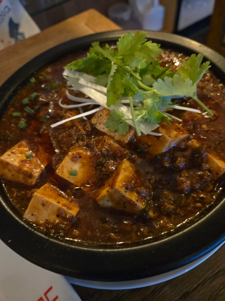 A bowl of mala mapo tofu topped with cilantro