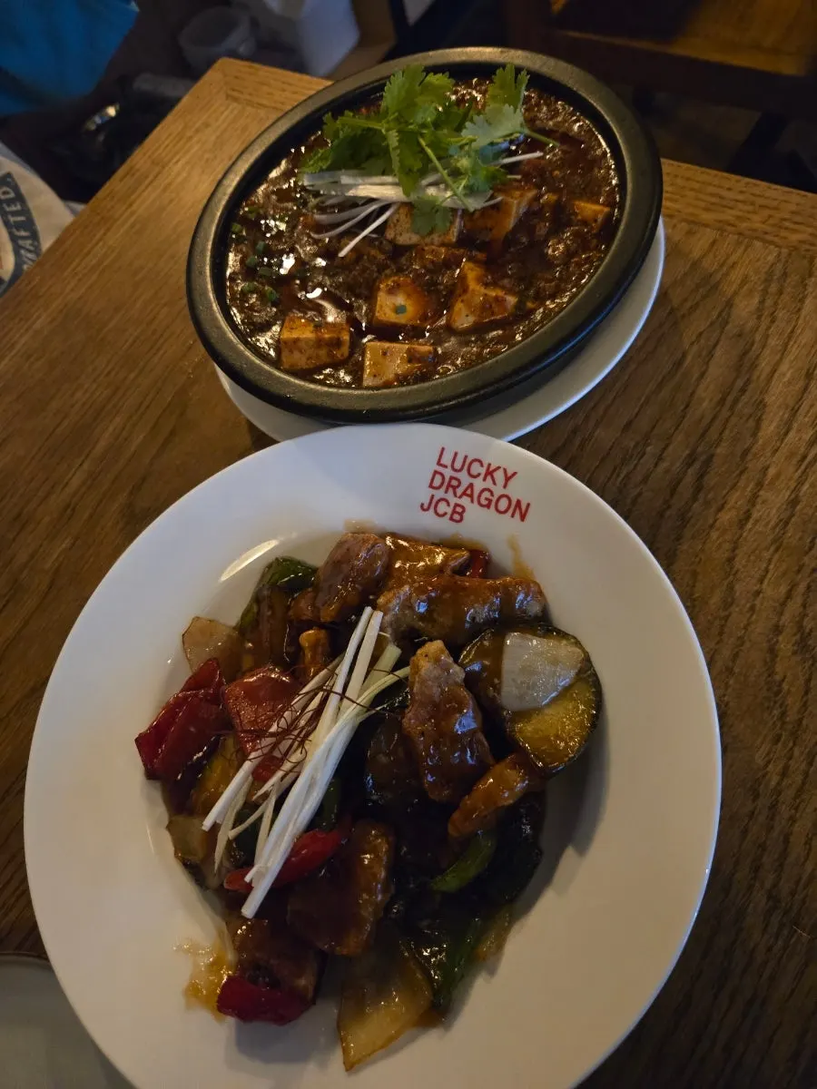 Table with mapo tofu, black vinegar pork, and draft beer together