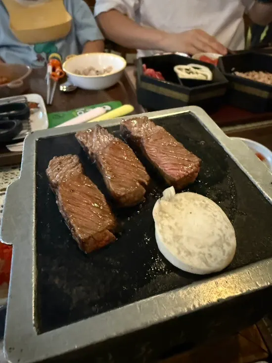 Steak yang sedang dipanggang di atas pelat panas