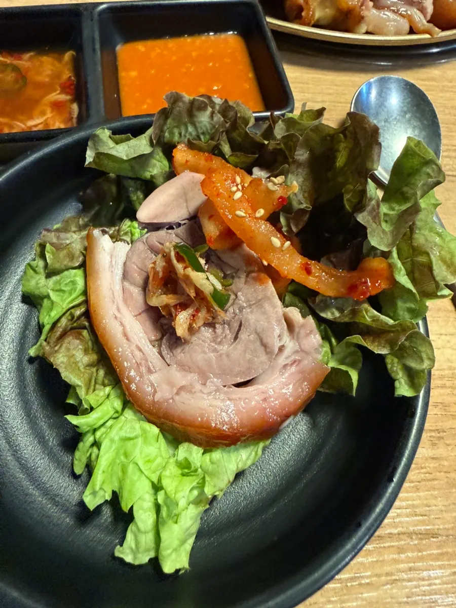 Jokbal dipped in salted shrimp and topped with radish kimchi