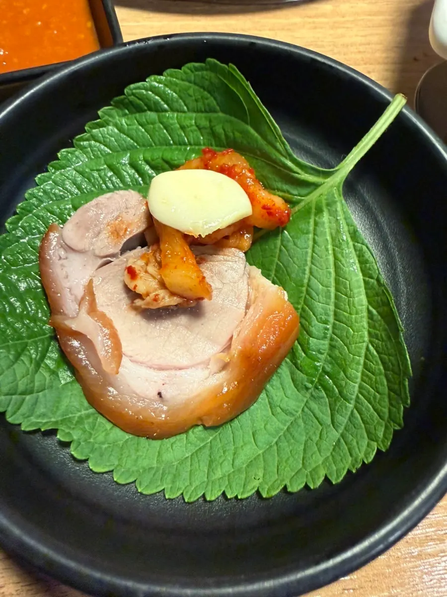 Perilla leaf wrap with jokbal, garlic and chive salad