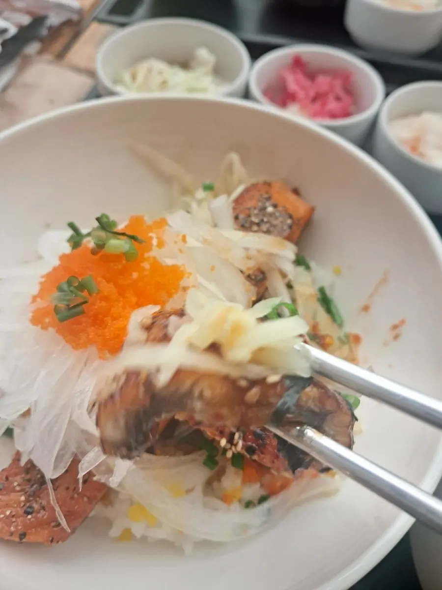 A bite of grilled eel brushed with sweet sauce