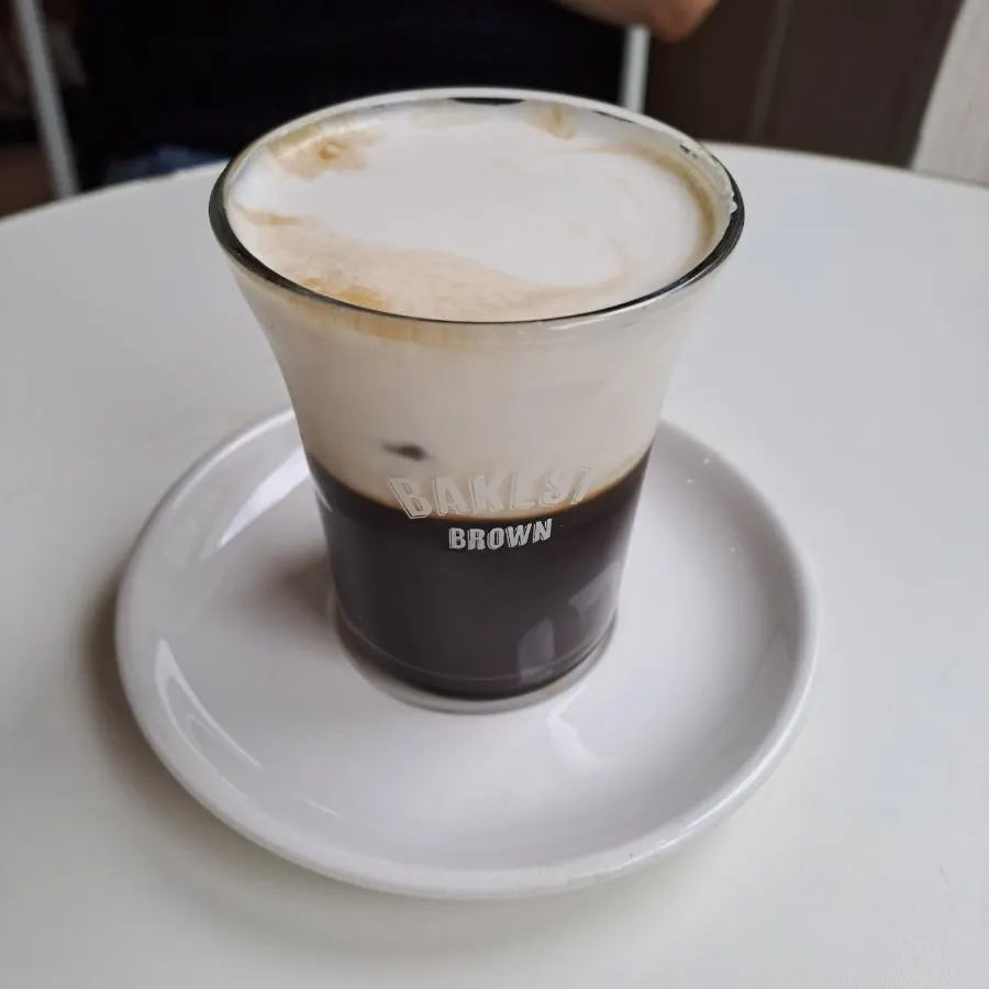 Salted cream coffee cup placed beside the cookie sand