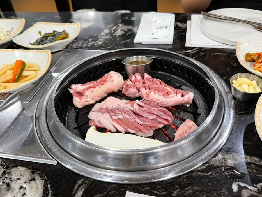 店員在烤盤上代烤黑豬肉