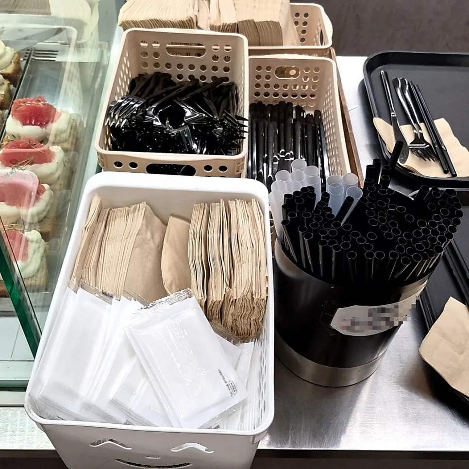 Self-serve station with napkins, forks, and straws