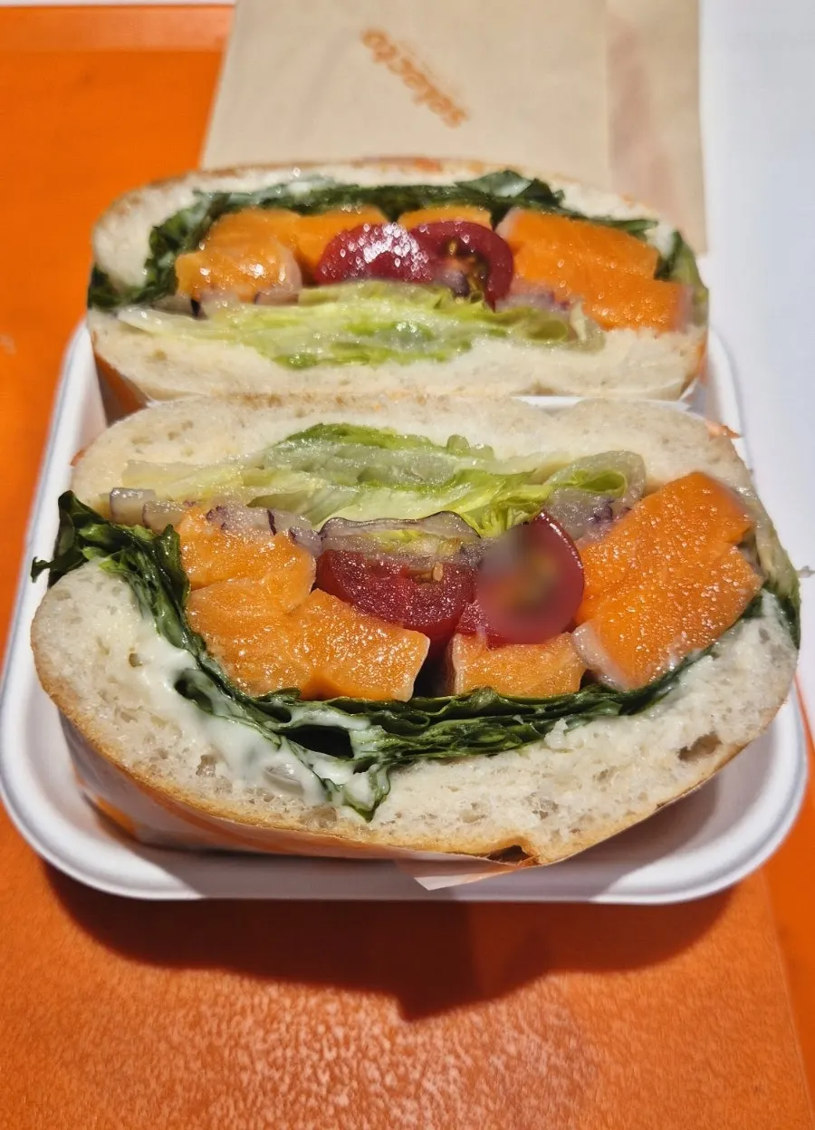 Cross-section of a generously filled smoked salmon sandwich