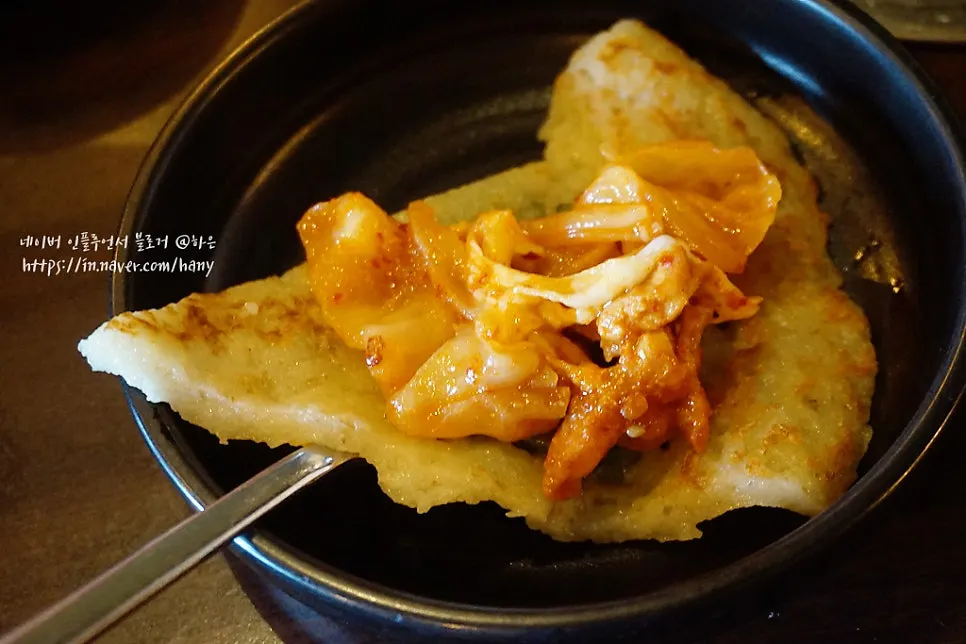 감자전에 닭갈비를 올려 싸 먹는 모습