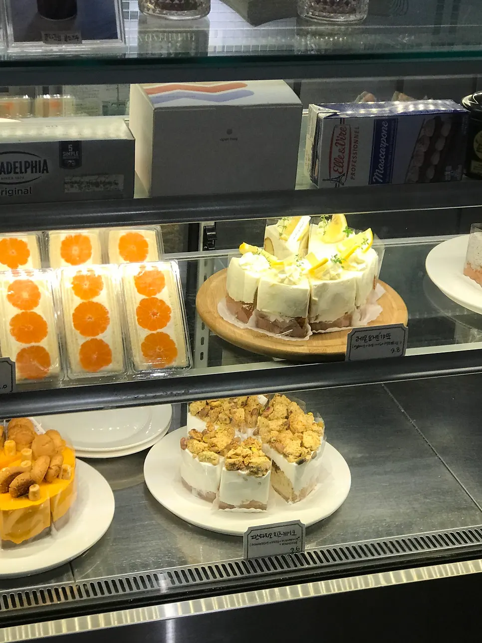Yellow cheesecake and pistachio cake on display