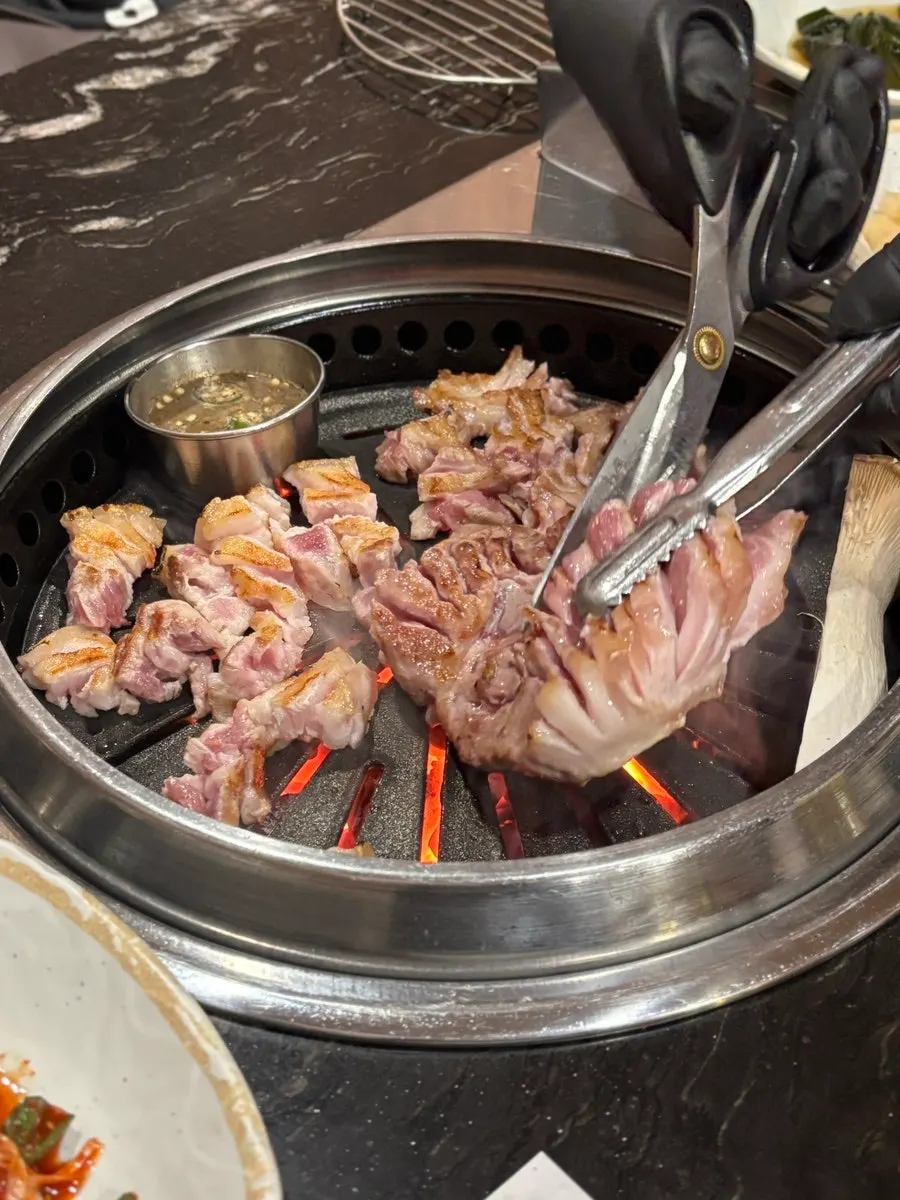 Pork belly and pork neck cooking on the grill