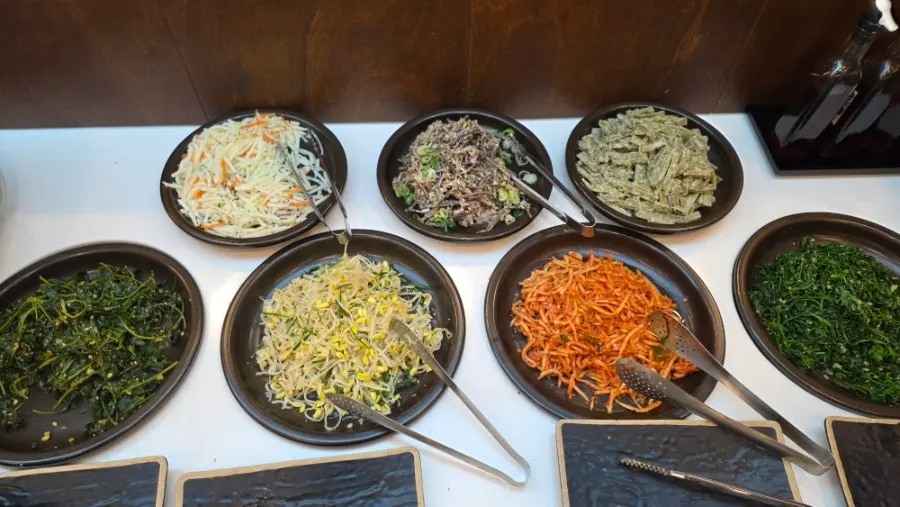 비빔밥 그릇과 나물이 준비된 비빔밥 코너