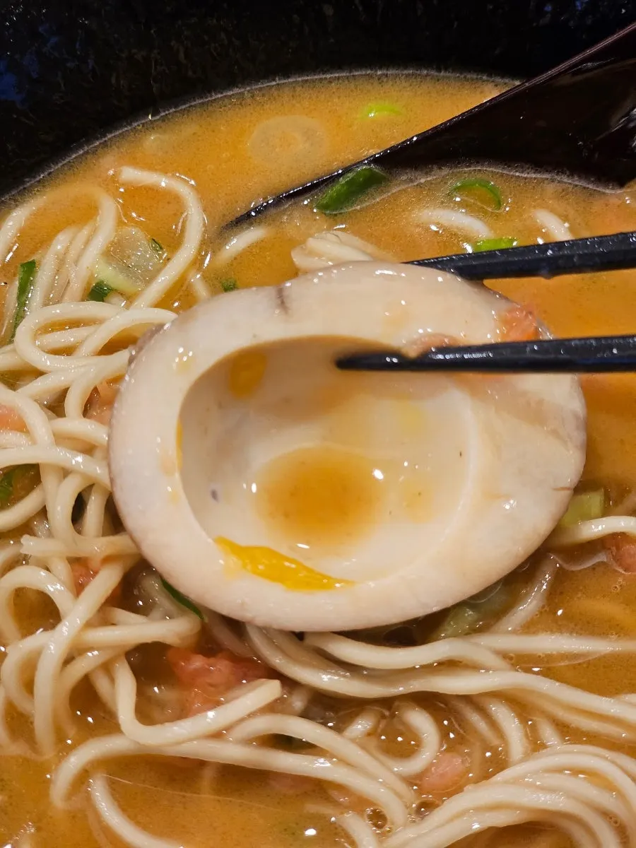 Seasoned egg sitting in the broth