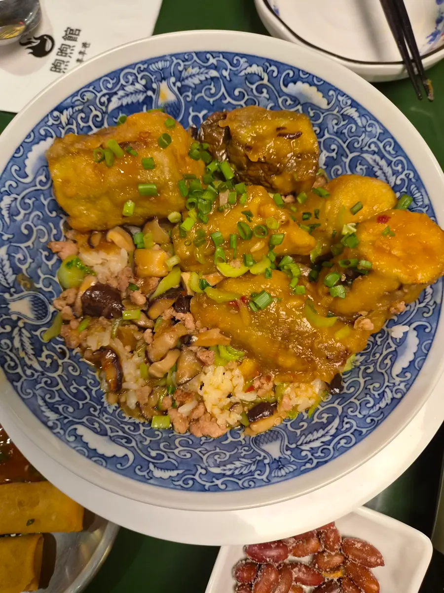 Fried dumplings topped with chili oil sauce and scallions
